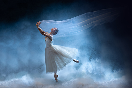 The Philadelphia Ballet Giselle key image of a ballerina in a white dress on stage.