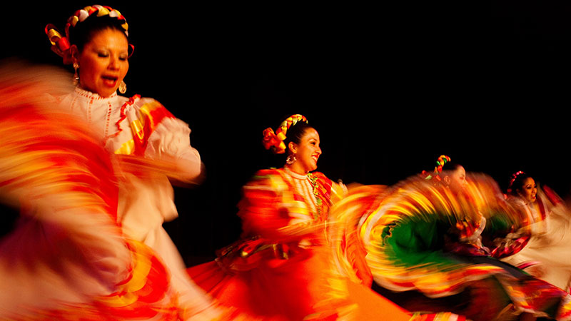 Latina dancers perform in colorful dresses