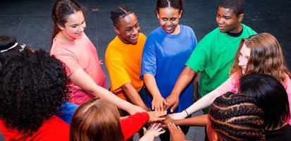 Students join hands at the center of a circle