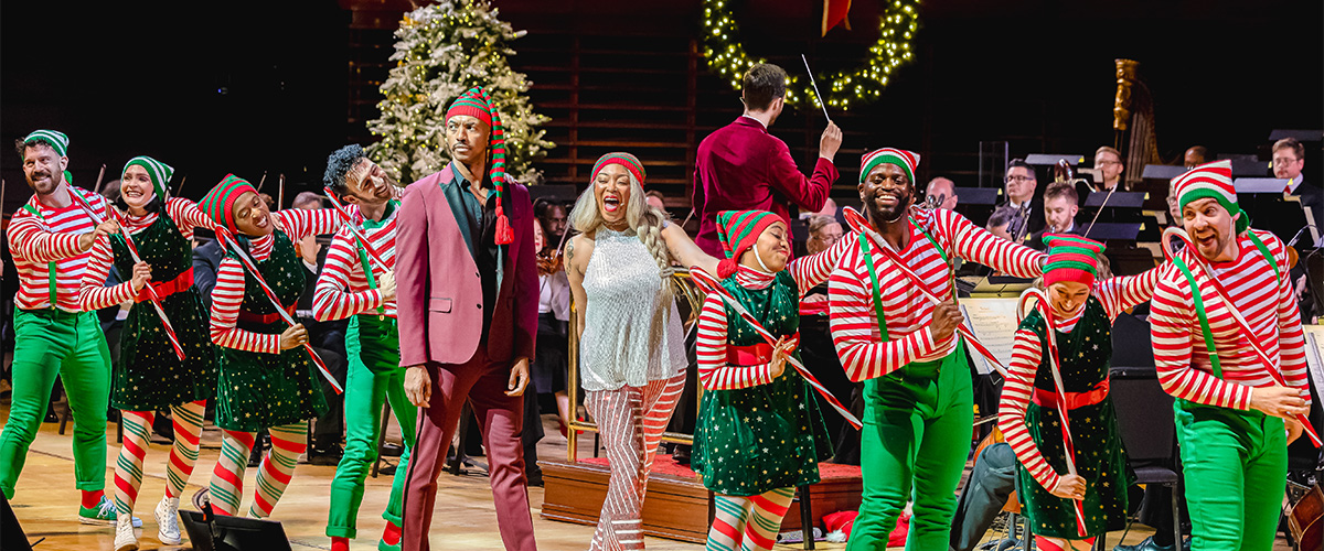 A Very Philly Christmas performers dressed as elves singing and dancing on stage.