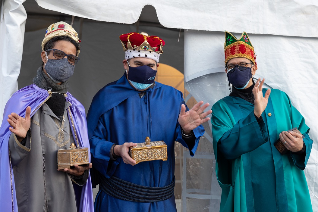 Three men dressed as the traditional "Three Kings" stand outside with gifts during an event in 2021 at Taller Puertorriqueno