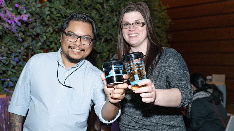 Two people hold up reusable Kimmel cups