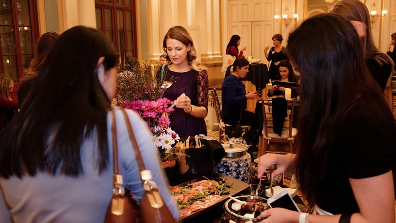 Event attendees grab food at an elegant gathering hosted in the Academy's Ballroom.