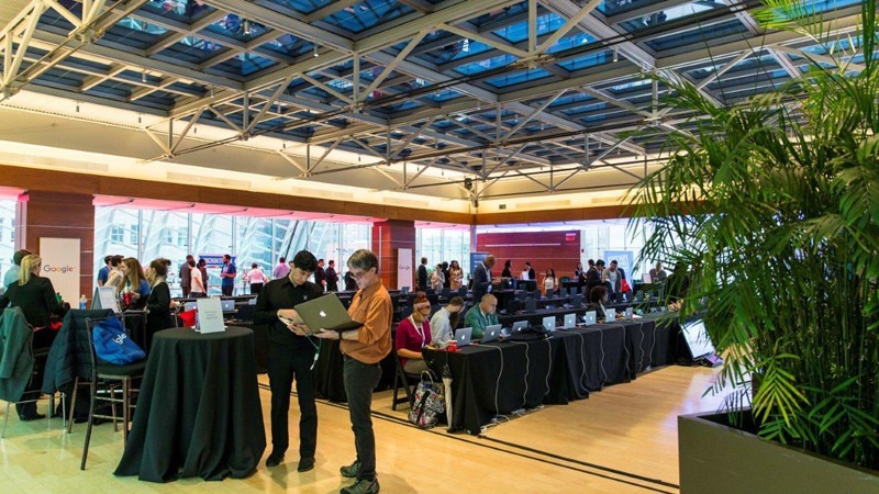 Rows of attendees fill the rooftop conference room at an event hosted by Google.