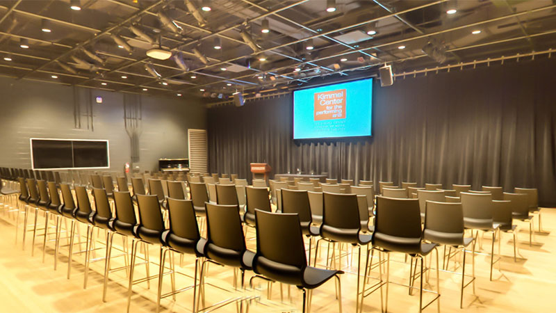 A podium, table, and chairs are arranged for a conference within the SEI Innovation Studio.